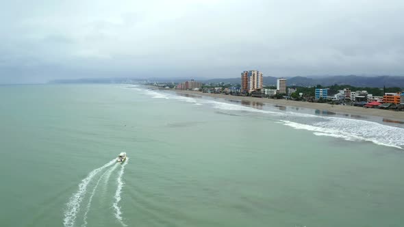 Aerial view, following a small boat going at a high speed over the waves 