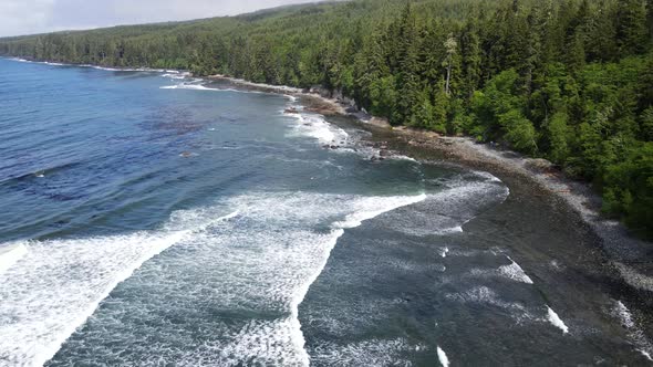 Sombrio beach revealed by 4k drone on a cloudy summer day with almost no one around. Big long waves