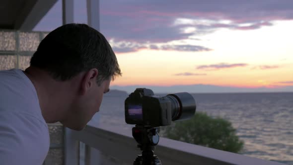 Man Shooting Timelapse of Sunset Over the Sea