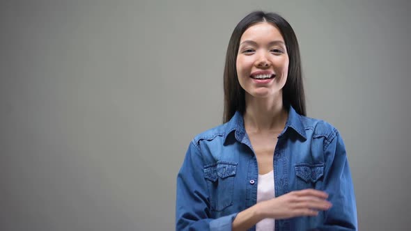 Smiling Young Asian Woman Standing With Hands Crossed and Looking on Camera