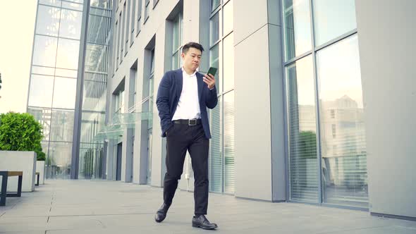 successful young confident businesswoman moving with cellphone in hands against 