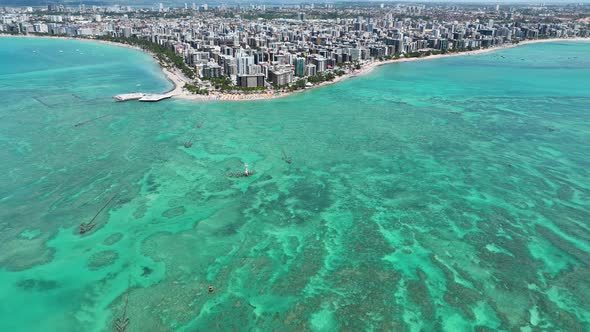 Aerial panning shot of turquoise water beach at Maceio Alagoas Brazil.