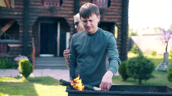 Travelling: Young Guy with Girl, Standing Near the Barbecue