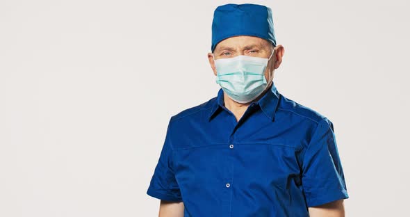 Mature Experienced Professional Doctor Prepared for Surgery Dressed in Blue Uniform with a Bandana