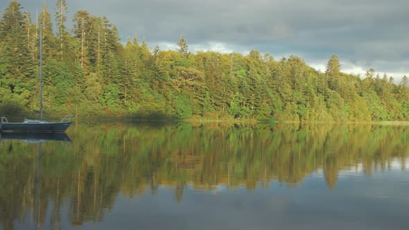 Incredible dream like view of sailboat moored looking out to vibrant wilderness lake view