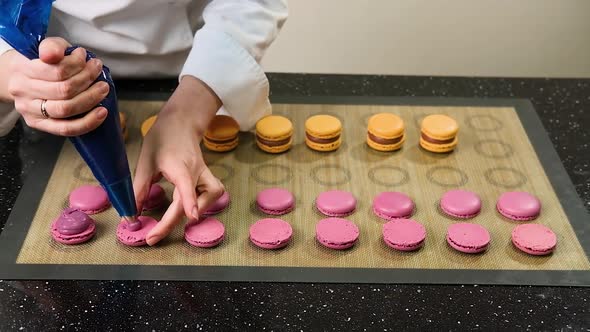 Pastry Chef Is Filling Cream Strawberry Macarons with Pastry Bag