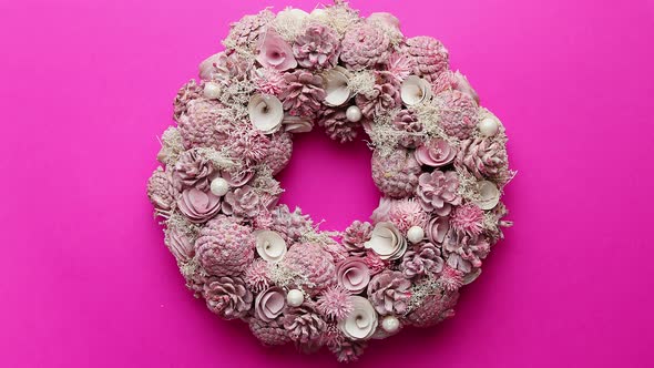 Christmas Wreath Made with Flowers, Pines and Leafs Isolated on Pink Background