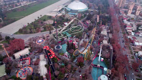 Tilt down aerial view of an amusement park with rides for the whole family, Santiago, Chile