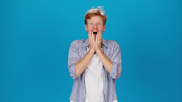 Young Redhead Man Gets Surprised Putting Hand on Face