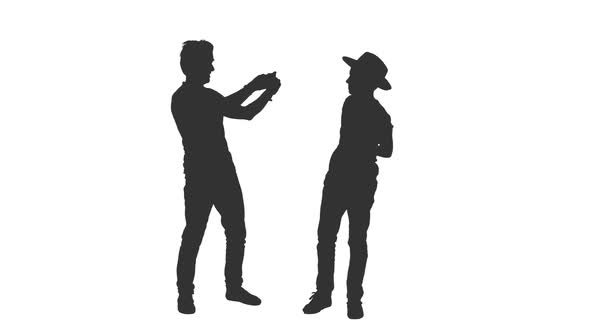 Silhouette of Father Takes a Picture of His Teen Son With Smartphone alt