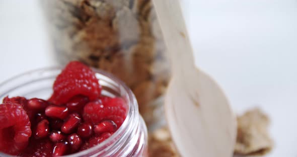 Raspberries and pomegranates in a jar 4k