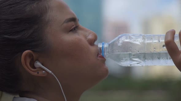 Close-up portrait young Asian woman runner drink water after running.