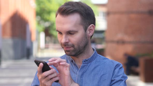 Portrait of Casual Man Busy Using Smartphone