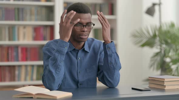 Upset Young African Man Feeling Worried While Sitting in Office