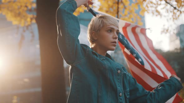 Young Blond Woman with USA Flag in the Park. Fair Presidential Elections Concept 