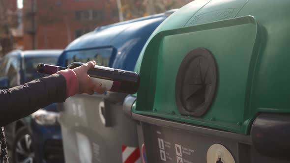 Woman's Hand Putting a Glass Bottle Into a Recycling Bin Street Barcelona Spain