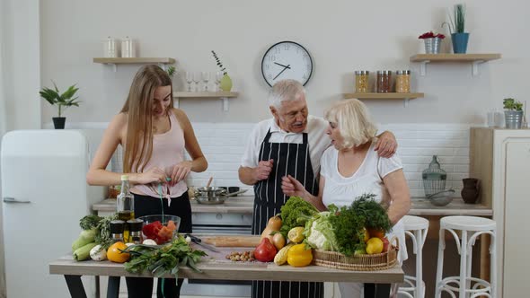 Girl Granddaughter Recommending Eating Raw Vegetable Food for Grandparents. Vegan Nutrition Diet