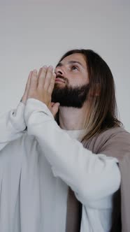 Jesus Prays with His Hands Together on a White Background