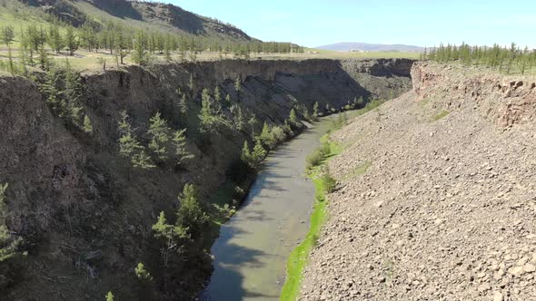 Broken Crumbled Rocks Spilling From the Narrow Canyon Slope Ridge Towards the Deep Valley Floor