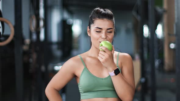 Portrait of Smiling Mixed Race Athletic Woman Eating Fresh Apple at Gym