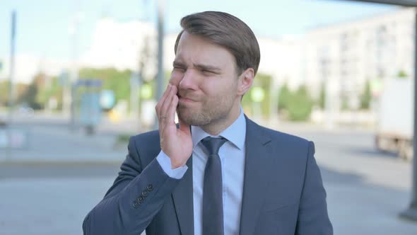 Portrait of Businessman having Toothache Outdoor