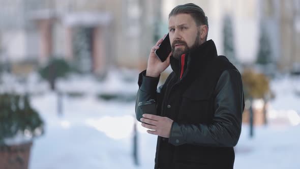 Man Having Mobile Talk on Snowy Street