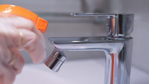 Close-up of a Spray of Cleaning Agent on a Chrome Faucet in the Bathroom. Hygiene, House Cleaning