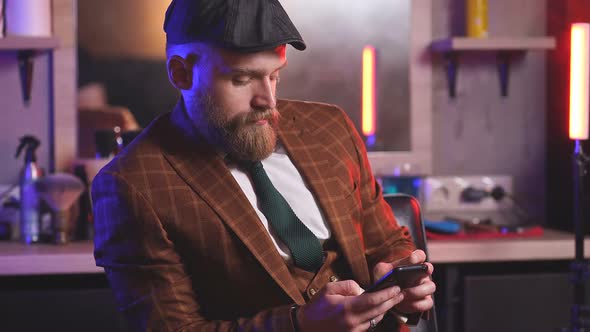 Elegant Stylish Businessman in Formal Costume Sits in Barber Shop