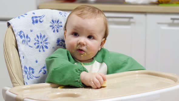 Little girl is trying to eat a banana, covered in bits of food, portrait shot