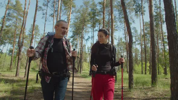 Portrait of Traveler Couple with Hiking Poles and Backpacks on Trek