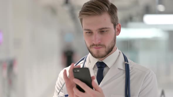 Young Male Doctor Using Smartphone in Office