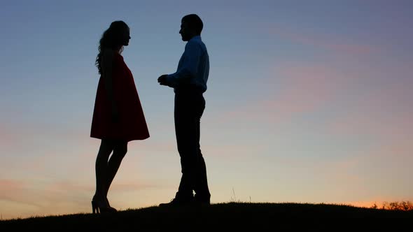 Guy Doing the Proposal for Girl Against a Beautiful Sky