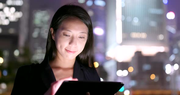 Young businesswoman use of tablet computer at night