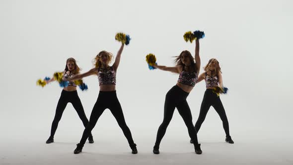 Group of Athletic Cheerleaders in Silver Tops and Black Tight Leggings are Dancing Cheering Dance on