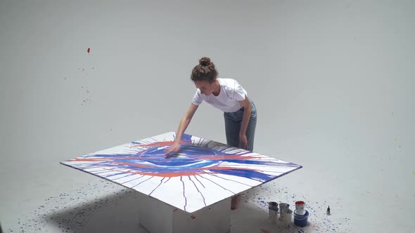 Female Artist Draws with Her Hands on a Large Canvas in a White Room a Talented Artist Draws a Color