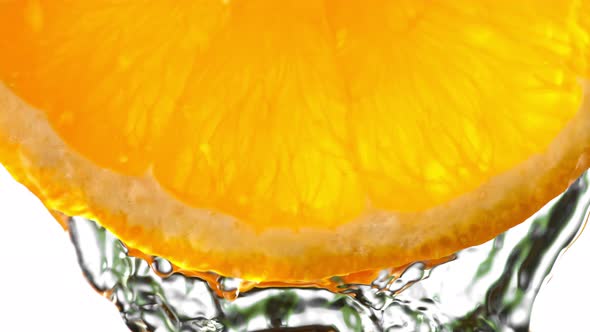 Super Slow Motion Macro Shot of Flowing Water From Fresh Orange Slice on White at 1000Fps