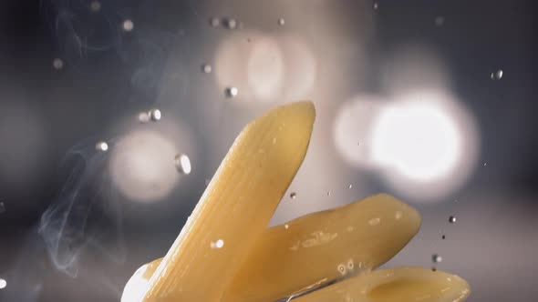 Pasta Penne is Flying Up on a Kitchen Bokeh Background