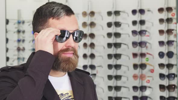 Mature Man Trying on Sunglasses at the Opticians Store