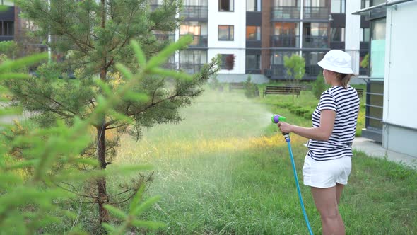 Woman watering backyard lawn