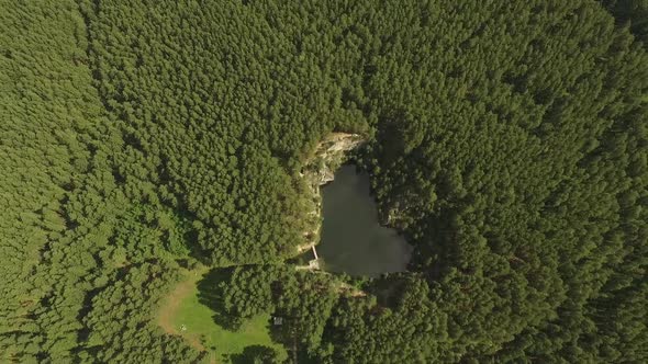 Small lake and talc rock in the forest. Aerial 04
