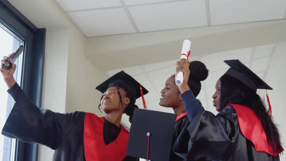 A Group of African American Students with Diplomas Make Selfie in the University Building