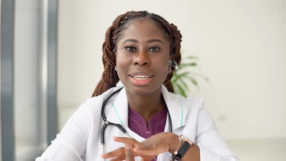 Young African American Woman Doctor Having Chat or Consultation on Laptop Looking Directly to the