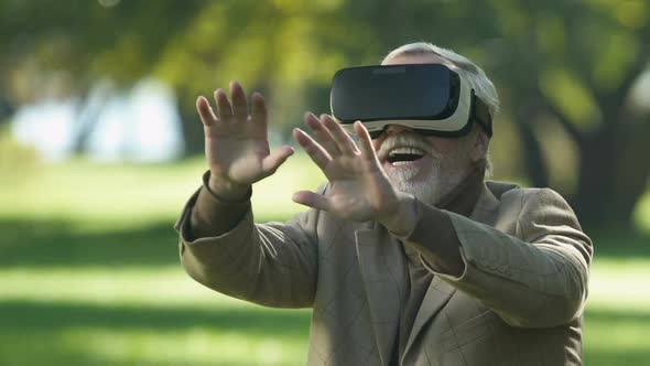 Old Man in Virtual Reality Headset Playing Simulator Game, Modern Technology