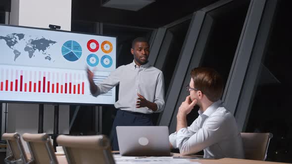 Young analyst telling colleague using tv multimedia