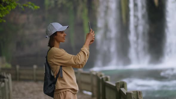 Attractive Smiling Woman Tourist Making Selfie on Mobile Phone on Lower Duden Waterfall Background