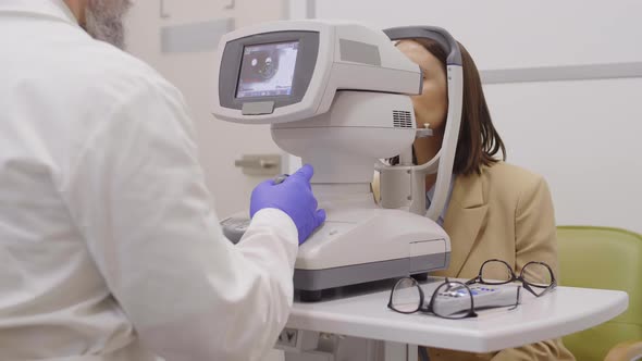 Woman Getting Eye Exam with Autorefractor in Ophthalmology Office