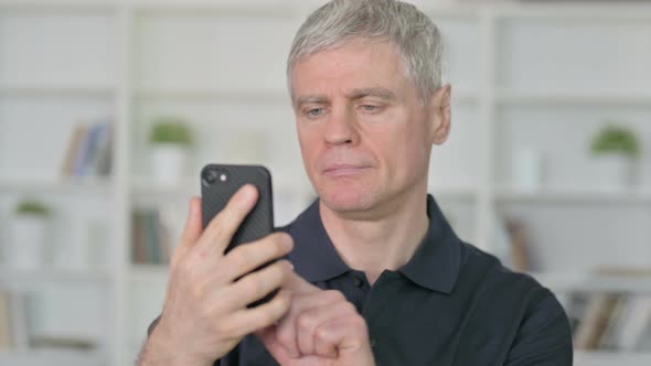 Relaxed Middle Aged Businessman Using Smartphone 