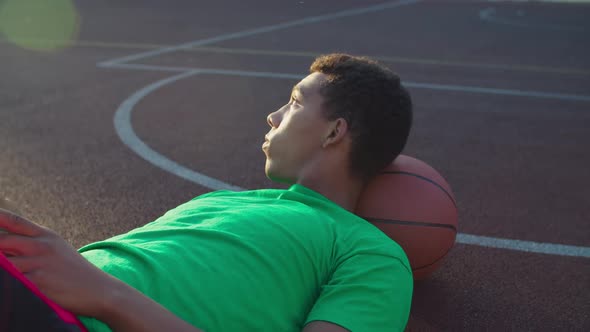 Basketball Player with Phone Resting After Training