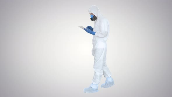 Healthcare Worker Wearing Hazmat Suit Working on Digital Tablet on Gradient Background