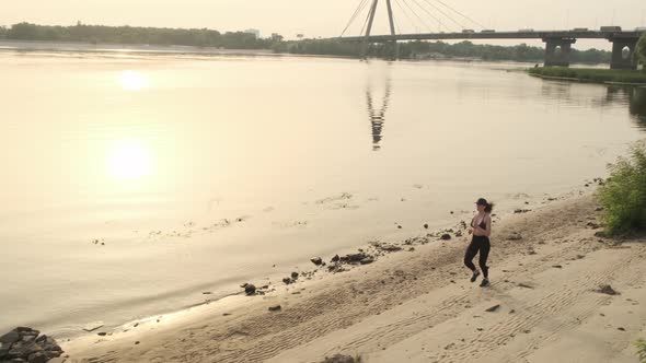 Fit and Healthy Young Woman Running Along Shoreline